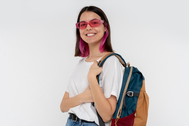 Portret van een tienermeisje dat een zonnebril draagt en haar rugzak vasthoudt