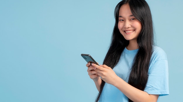 Portret van een tienermeisje dat haar telefoon controleert met kopieerruimte