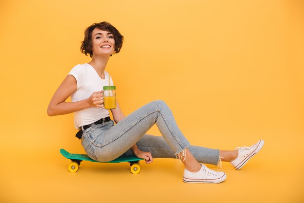 Portret van een vrij schattige vrouw zittend op een skateboard