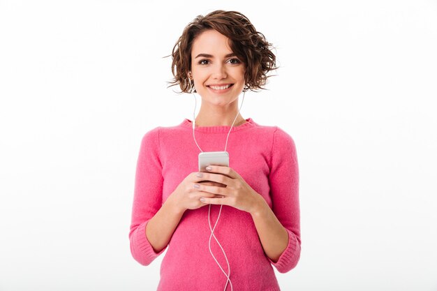 Portret van een vrolijk mooi meisje dat aan muziek luistert