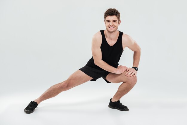 Portret van een vrolijke gezonde mens die vóór gymnastiek opwarmt