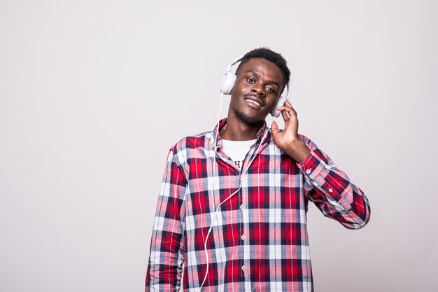 Portret van een vrolijke jonge afro Amerikaanse man, luisteren naar muziek met een koptelefoon en zingen geïsoleerd
