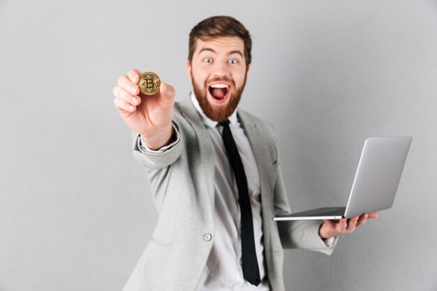 Portret van een vrolijke zakenman die bitcoin toont