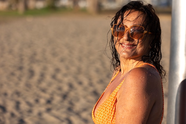 Gratis foto portret van een vrouw die een douche neemt op het strand