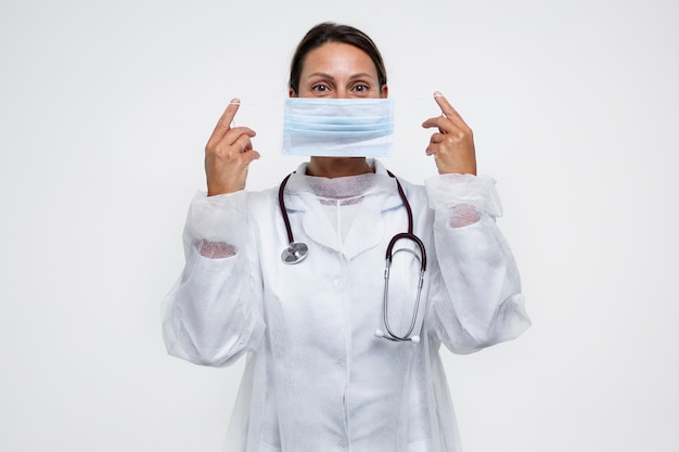 Portret van een vrouw die een medische toga draagt en een medisch masker opzet