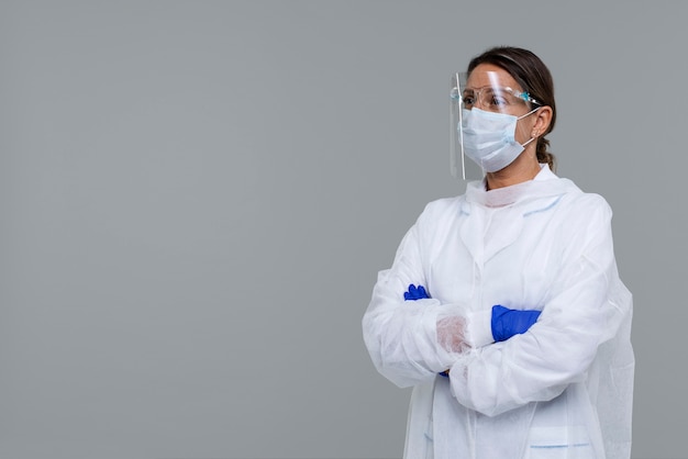 Gratis foto portret van een vrouw die een medische toga draagt met handschoenen en gezichtsschild