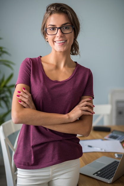 Portret van een vrouw die in haar huisbureau werkt