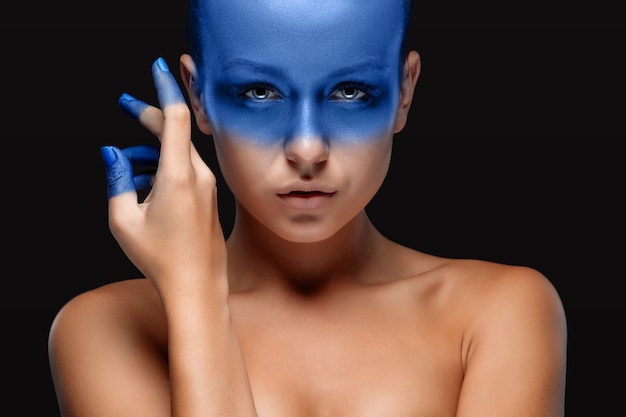 Portret van een vrouw die poseert bedekt met blauwe verf