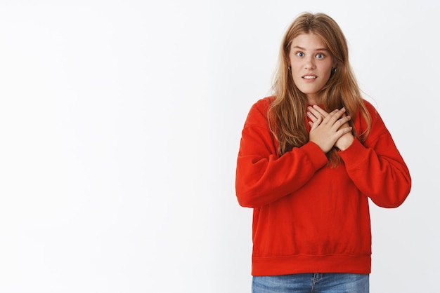 Portret van een vrouw die tot het diepst van haar ziel verrast is en haar handen naar het hart drukt en er ondervraagd en verbaasd uitziet