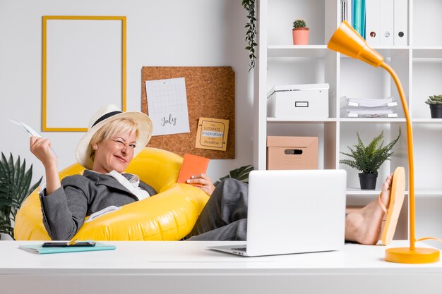 Portret van een vrouw in het kantoor bereid voor de zomervakantie