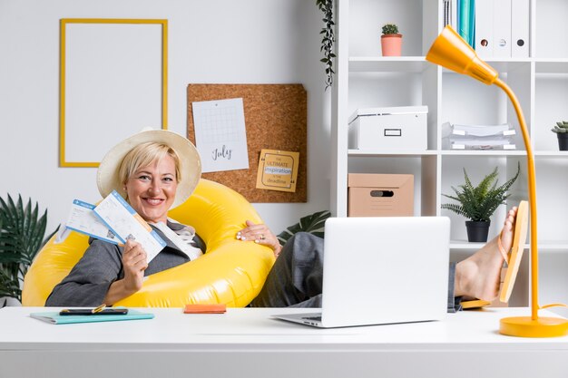 Portret van een vrouw in het kantoor bereid voor de zomervakantie