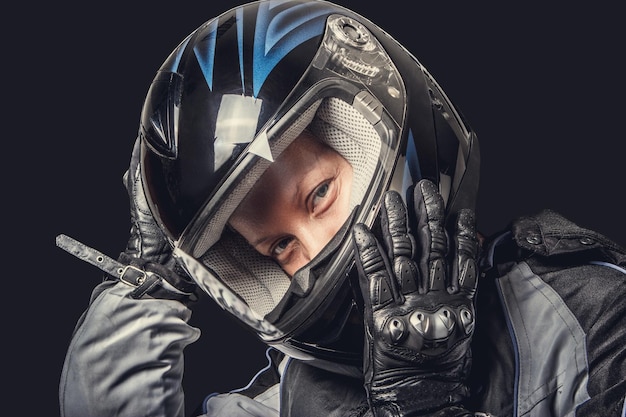 Portret van een vrouw in motorfiets veiligheidskostuum en zwarte helm.