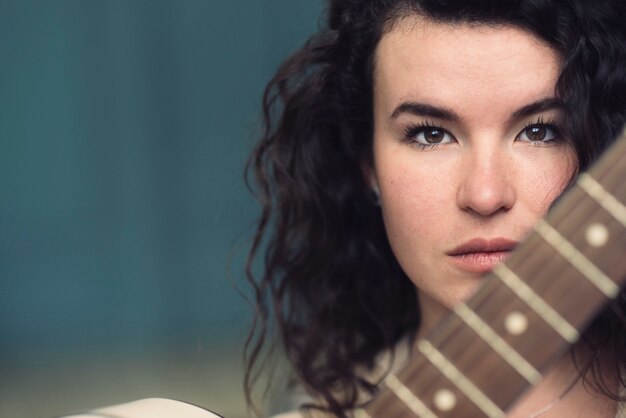 Gratis foto portret van een vrouw met gitaar