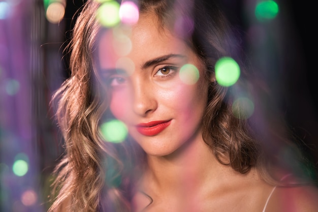 Gratis foto portret van een vrouw met golvend haar en wazig sparkles effect