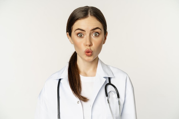 Portret van een vrouwelijke arts die verbaasd kijkt, een verbaasde reactie van interesse en amusement die in een ziekenhuis staat...
