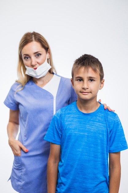 Portret van een vrouwelijke tandarts en een jongen op witte achtergrond