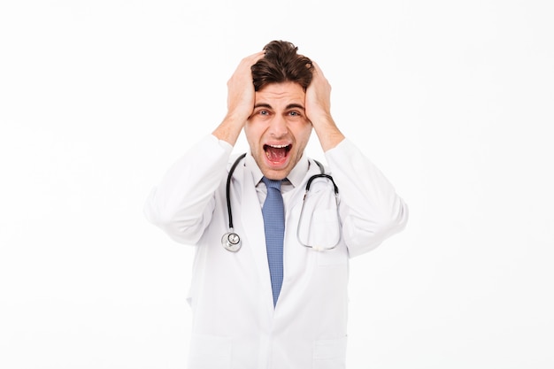 Portret van een woedende gekke mannelijke artsenmens met stethoscoop