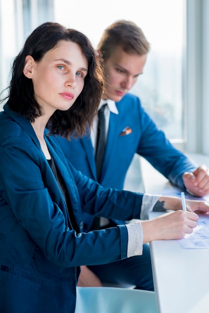 Portret van een zakenvrouw zitten met haar mannelijke collega in het kantoor