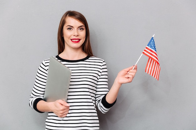 Portret van een zekere vrouw die Amerikaanse vlag houdt