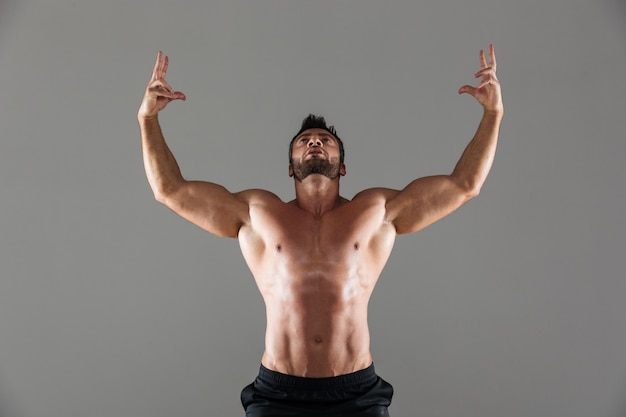 Portret van een zelfverzekerde sterke shirtless mannelijke bodybuilder poseren