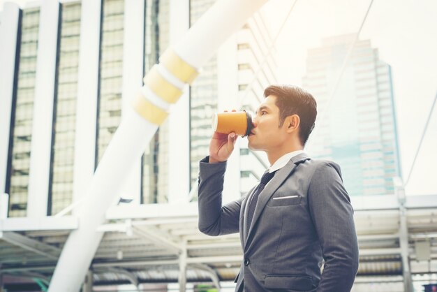 Portret van een zelfverzekerde zakenman die koffie in openlucht drinkt