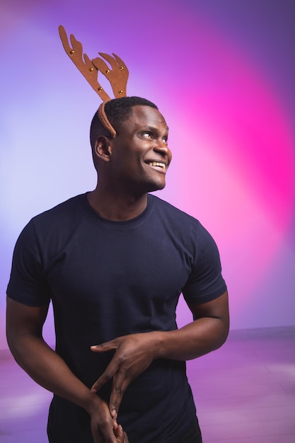 Portret van emotionele afro-amerikaanse man draagt rudolph hertenhoorns geniet van zijn accessoire voor Premium Foto