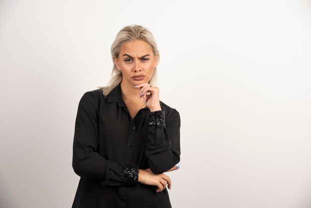 Portret van ernstige vrouw in zwart shirt poseren op witte achtergrond. hoge kwaliteit foto