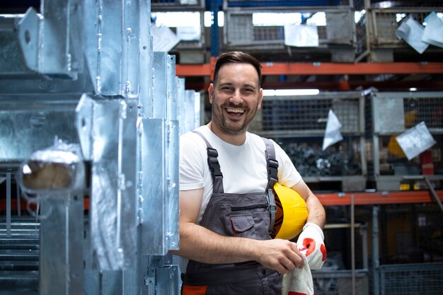 Gratis foto portret van fabrieksarbeider permanent in fabriek productiehal