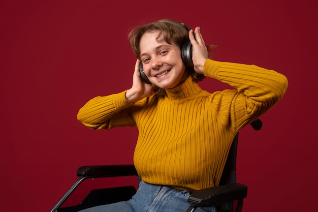 Portret van gehandicapte vrouw in een rolstoel met koptelefoon