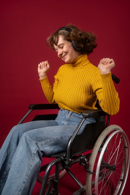 Portret van gehandicapte vrouw in een rolstoel met koptelefoon