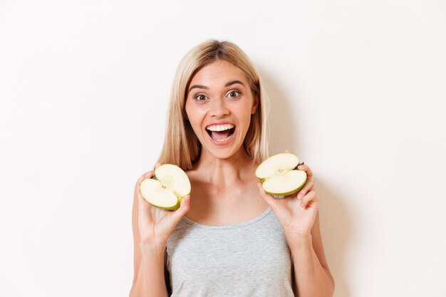 Portret van gelukkig opgewekt in ondergoed dat gesneden appel houdt