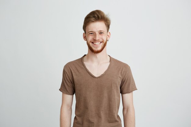 Portret van gelukkig vrolijke jonge man met baard glimlachen.