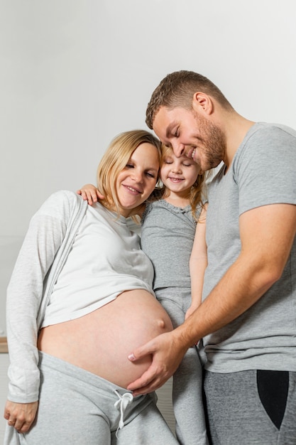 Gratis foto portret van gelukkige familie wat betreft moederbuik