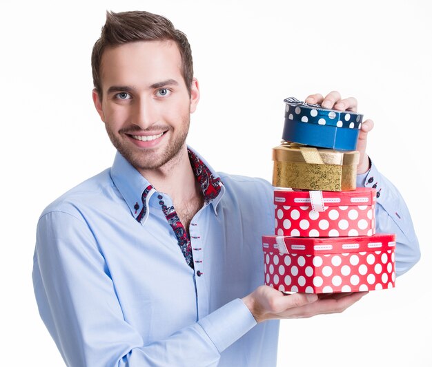 Portret van gelukkige jonge man met geschenken - geïsoleerd op wit