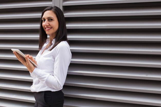 Portret van gelukkige jonge zakenvrouw met behulp van digitale tablet