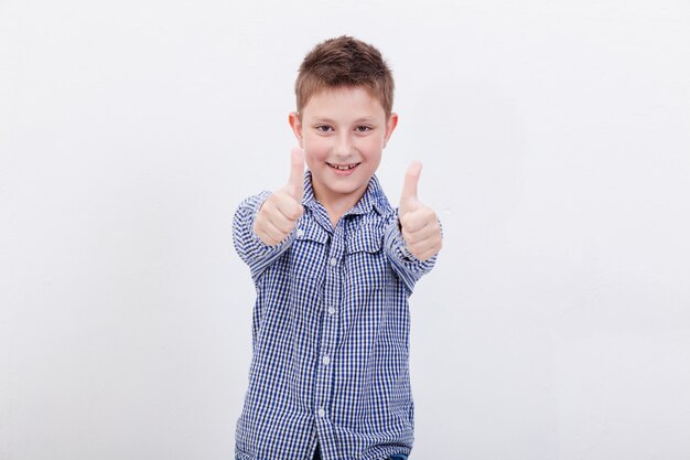 Portret van gelukkige jongen duimen opdagen gebaar