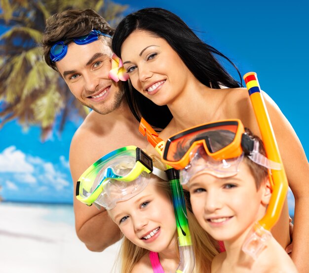 Portret van gelukkige leuke mooie familie met twee kinderen op tropisch strand met beschermend zwemmasker