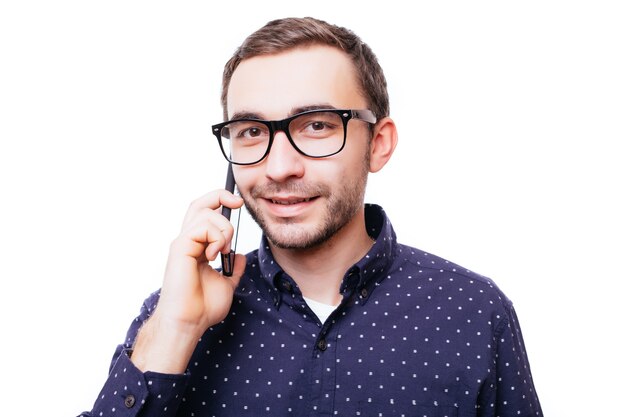 Portret van gelukkige man praten over de telefoon geïsoleerd op een witte muur