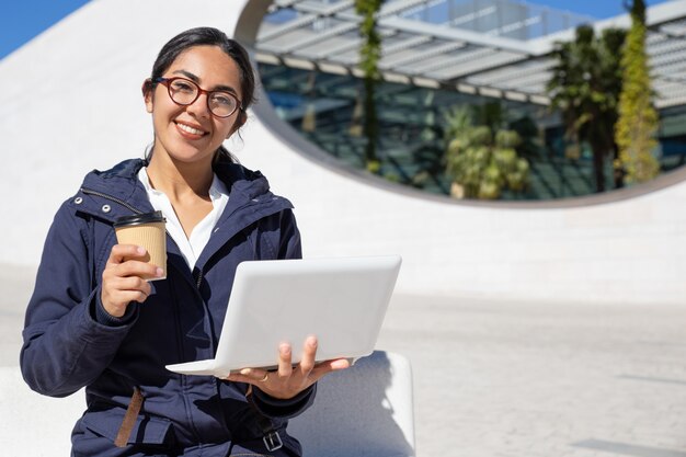 Portret van gelukkige onderneemster die koffiepauze in openlucht hebben