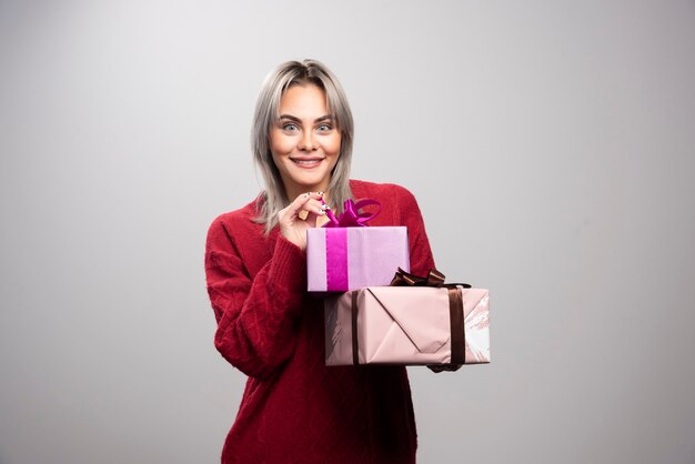 Portret van gelukkige vrouw met geschenkdozen poseren.