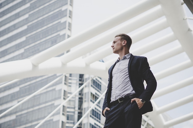 Portret van gelukkige zakenman die zich op voorzijde van commercieel centrum bevindt.