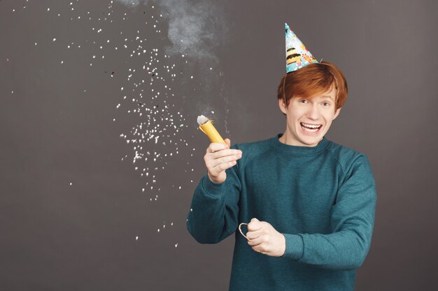 Portret van gember jongen op verjaardag met vrienden doorbrengen in warme en gelukkige sfeer.