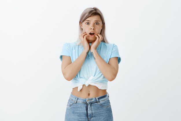 Portret van geschokt bang blond meisje poseren in de studio