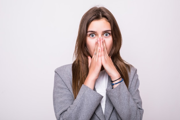 Portret van geschokte vrouw met open mond het kijken weg op een grijze achtergrond