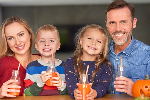 Portret van glimlachende familie die smoothie drinkt