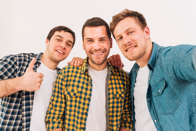 Portret van glimlachende jonge mannelijke vrienden die camera bekijken
