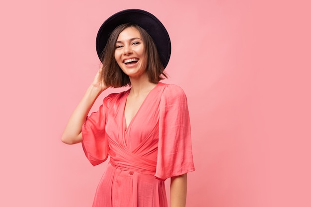portret van Graceful lachende brunette vrouw in roze jurk