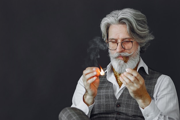 Gratis foto portret van grijnzende ouderwetse man close-up. grootvader met een sigaar.
