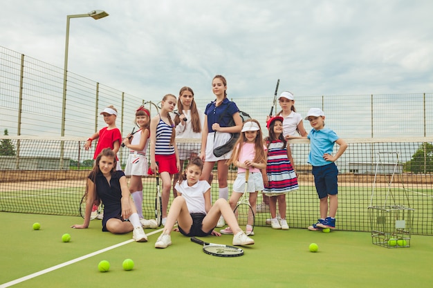 Portret van groep meisjes als tennisspelers die tennisracket houden