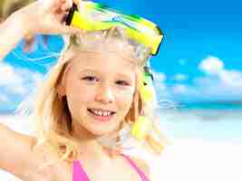 Gratis foto portret van het gelukkige meisje die bij strand genieten van. schoolkind meisje met zwemmend masker op hoofd.